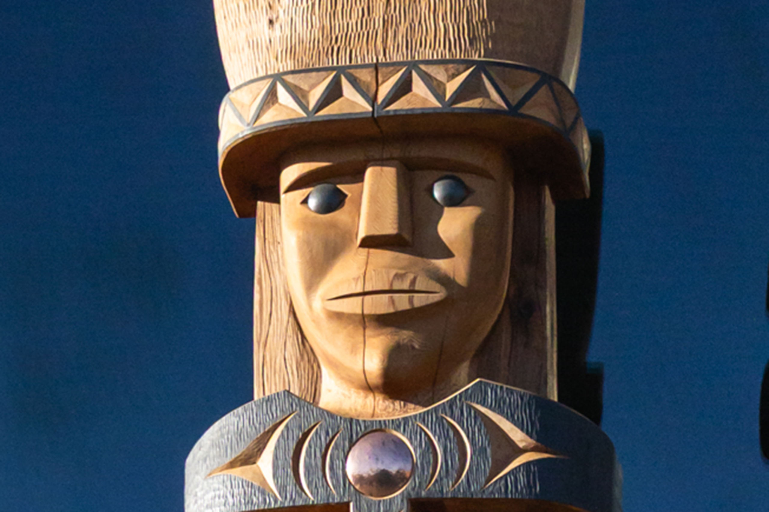 A close-up on a portion of the house post carved by Brent Sparrow